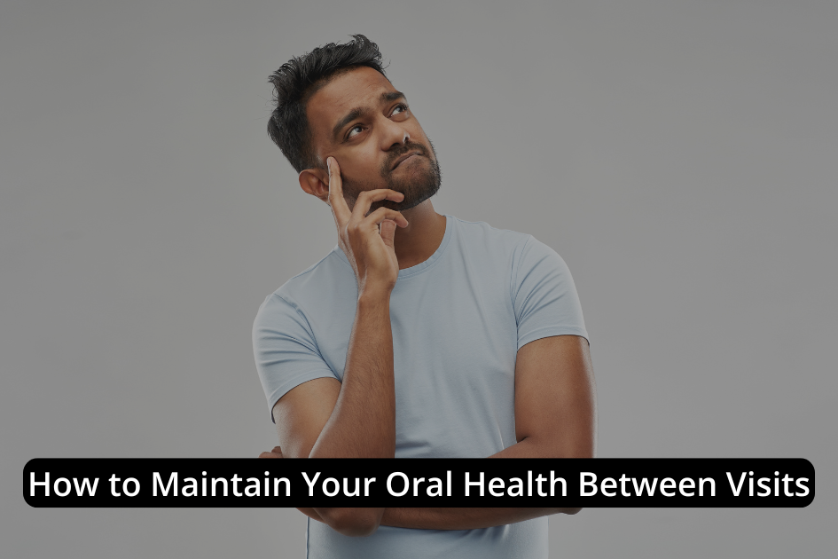 A man in a light blue shirt stands thinking, with the text "How to Maintain Your Oral Health Between Visits" displayed across the image.